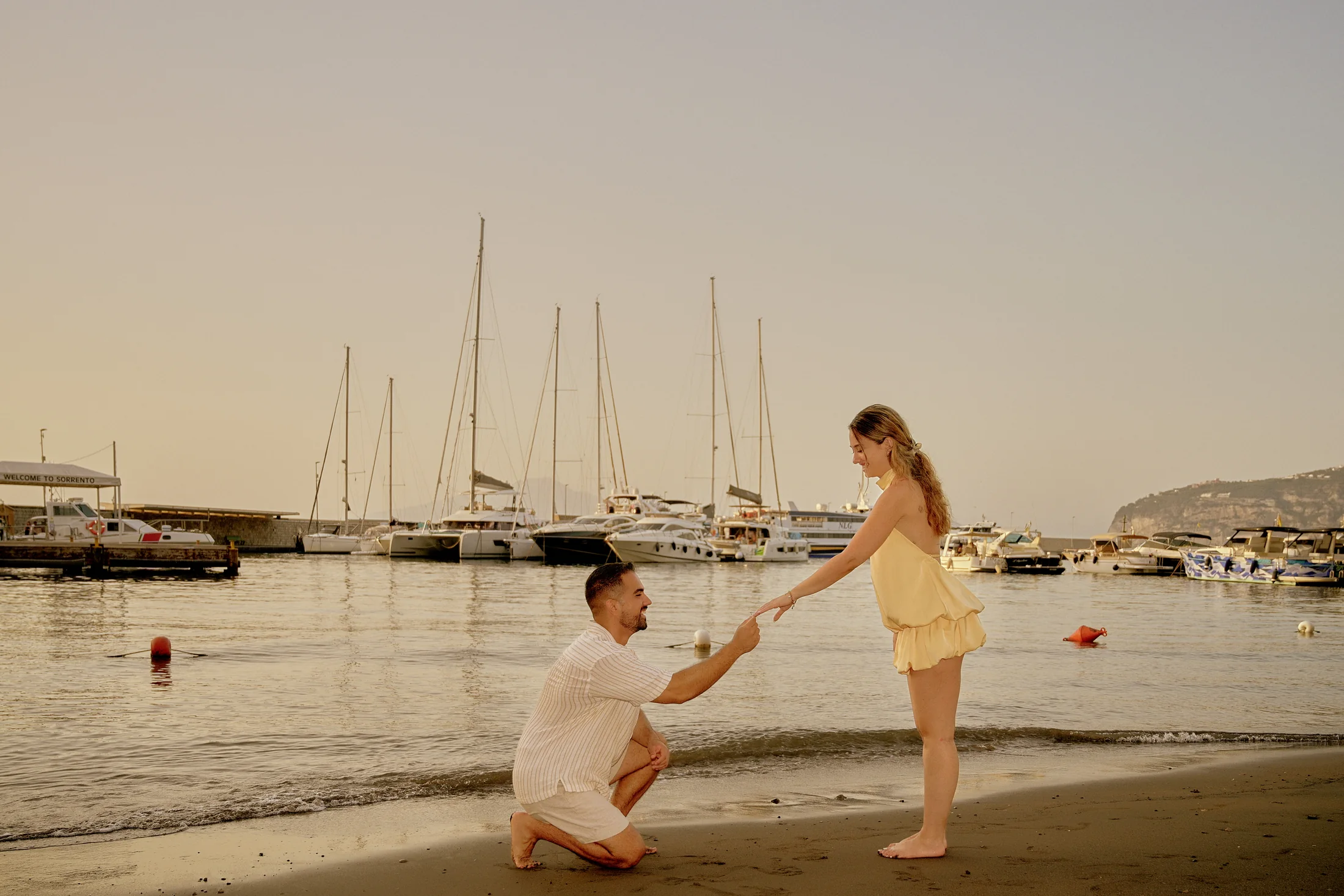 Costantinos proposing to Nicole by the sea at Marina Piccola in Sorrento