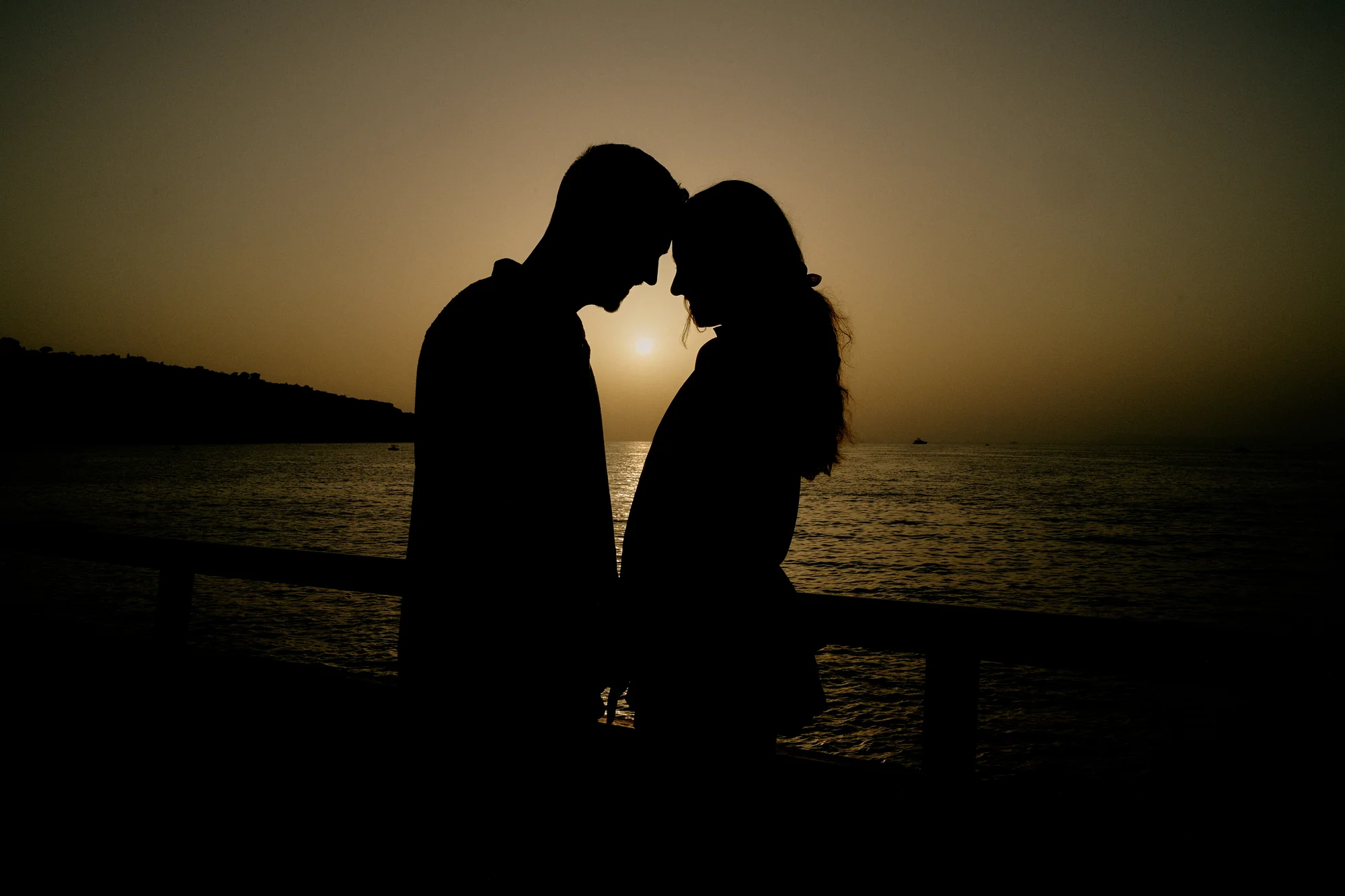 Romantic silhouette of an engaged couple at sunset in Sorrento