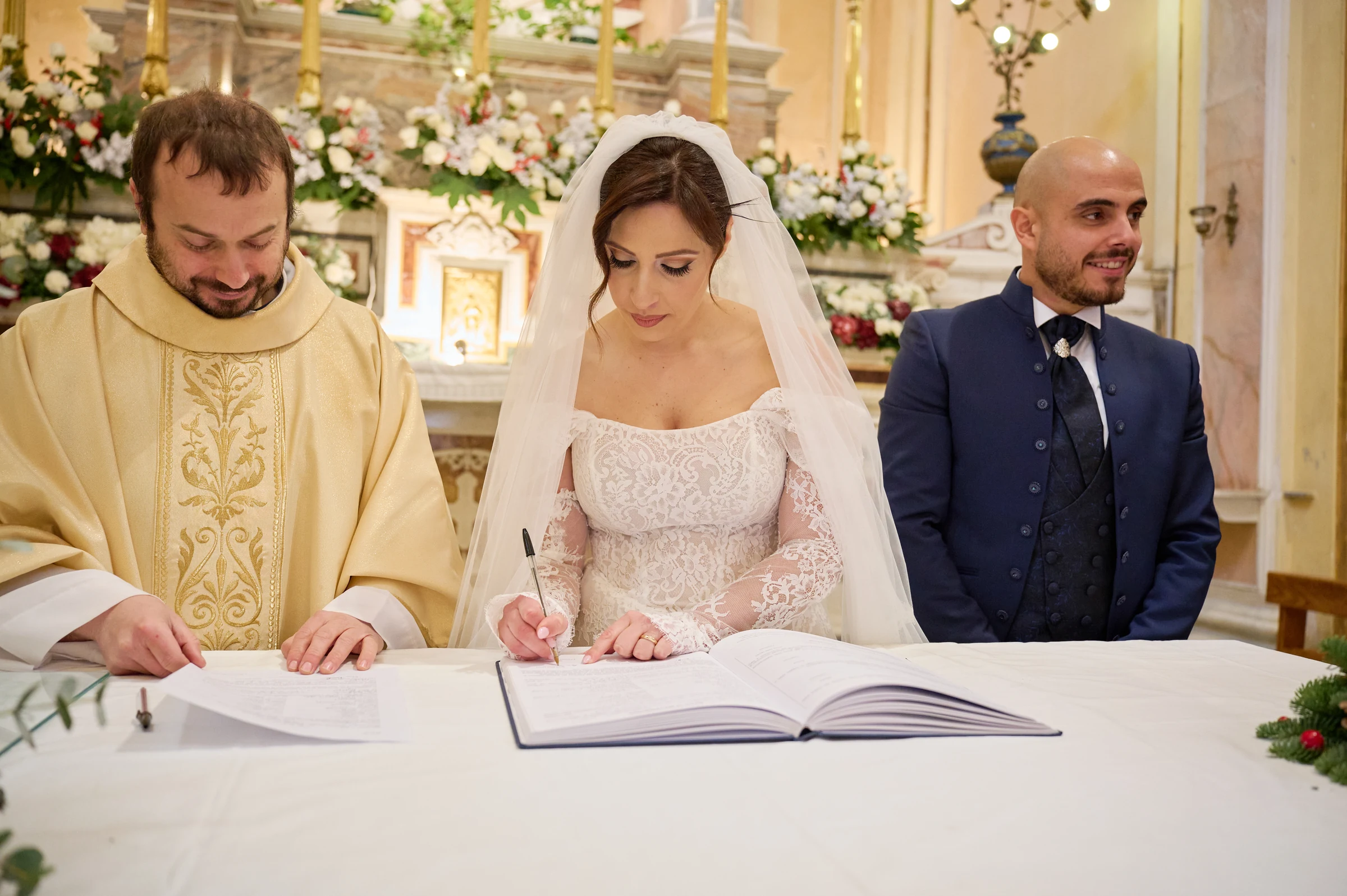 Rosa signing the wedding register beside Ciro and the priest at the sanctuary in Gragnano.
