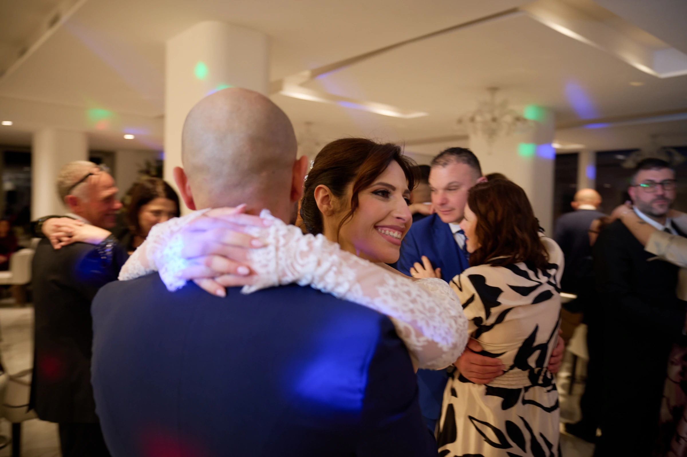 Rosa smiling as she dances with Ciro among the guests at their wedding reception at Le Rocce in Agerola.