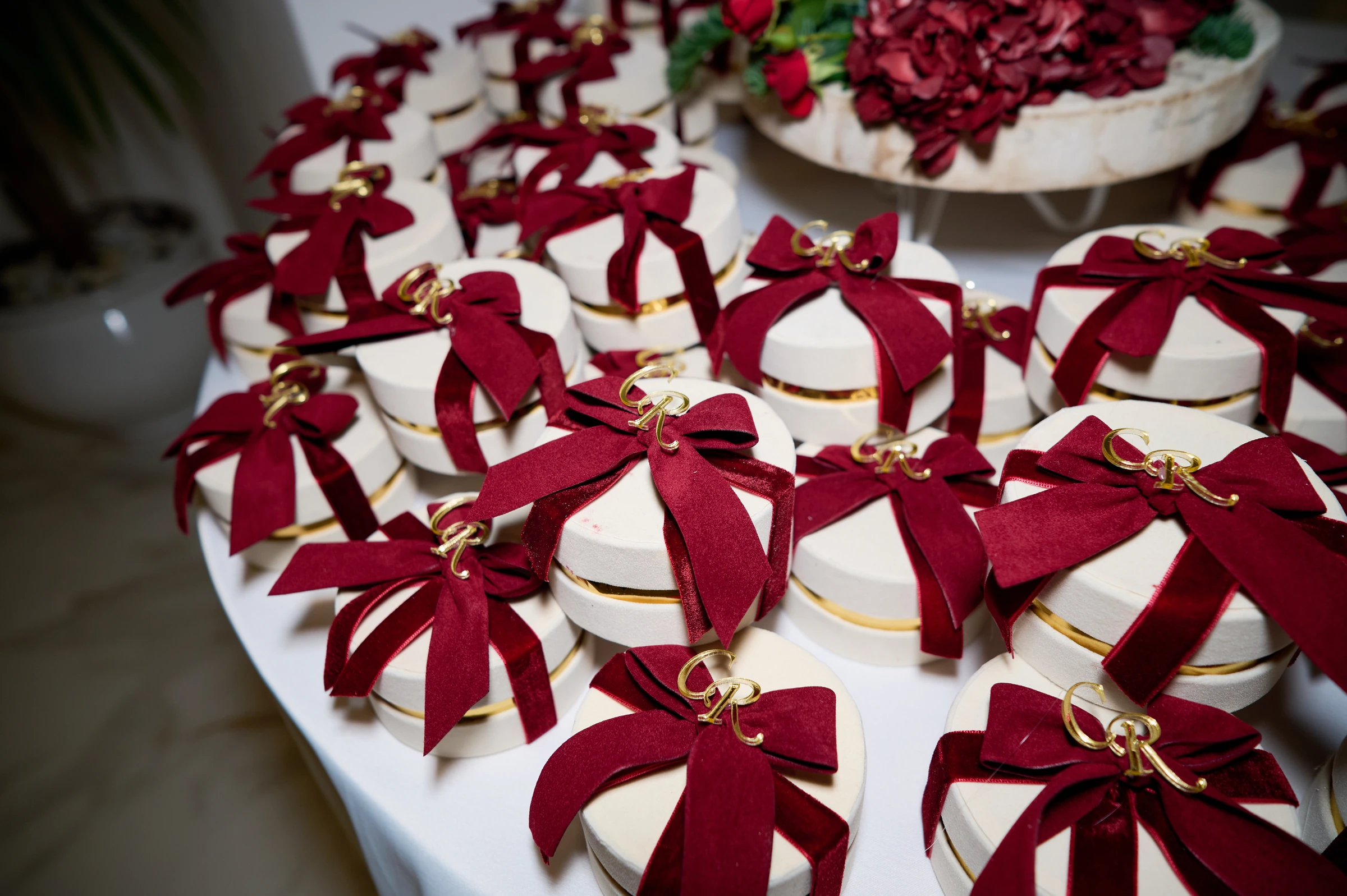 White wedding favour boxes decorated with burgundy bows at Ciro and Rosa’s reception at Le Rocce in Agerola.