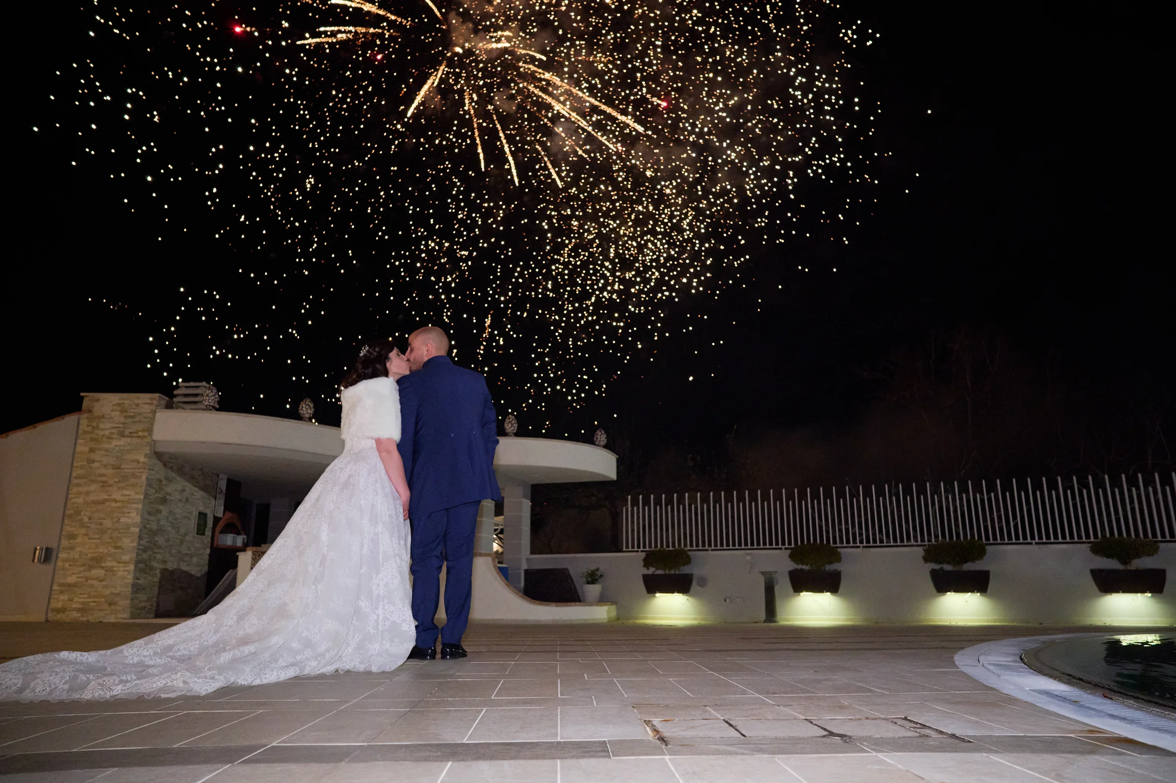 Ciro and Rosa standing together beneath fireworks at the end of their wedding celebration at Le Rocce in Agerola.