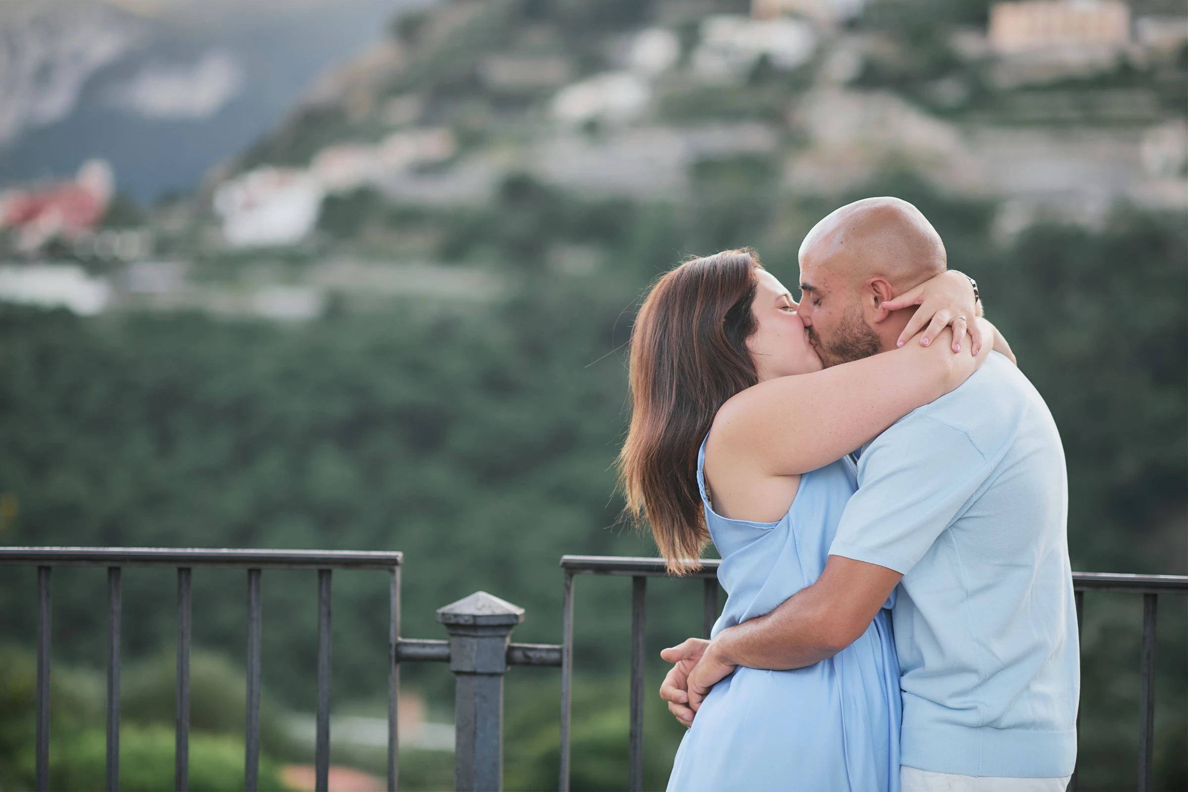 Ciro and Rosa kissing during their engagement photoshoot in Ravello, with the hillside softly blurred behind them.
