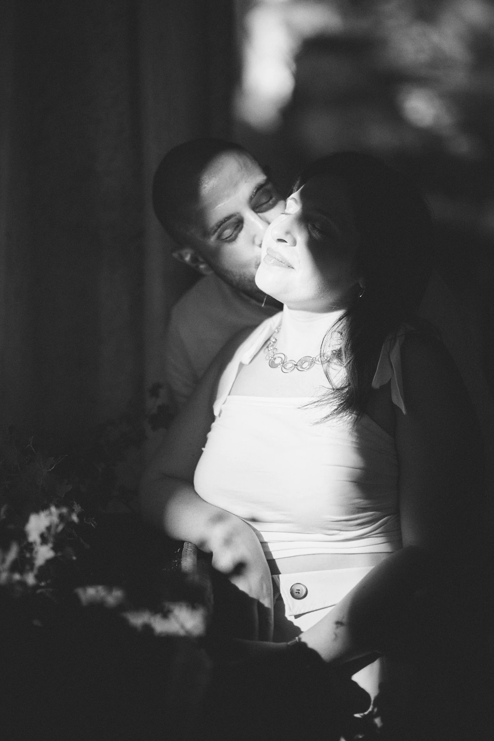 Black and white portrait of Ciro leaning close to Rosa as sunlight falls across her face at Villa Rufolo.