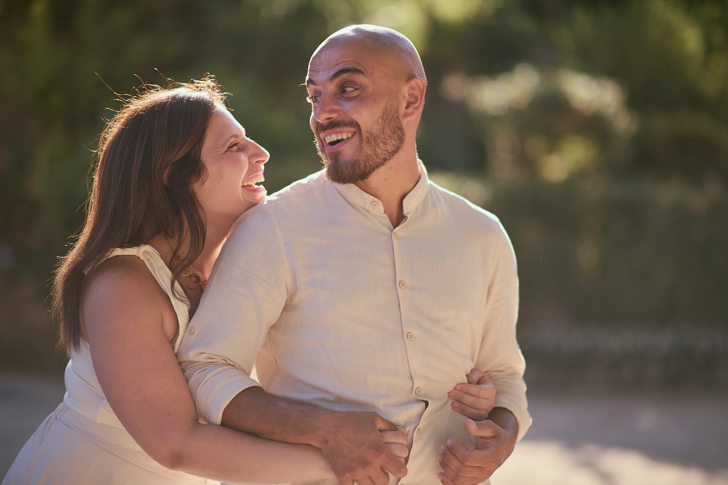 Ciro embraces Rosa from behind as they smile in the warm light at Villa Rufolo in Ravello.