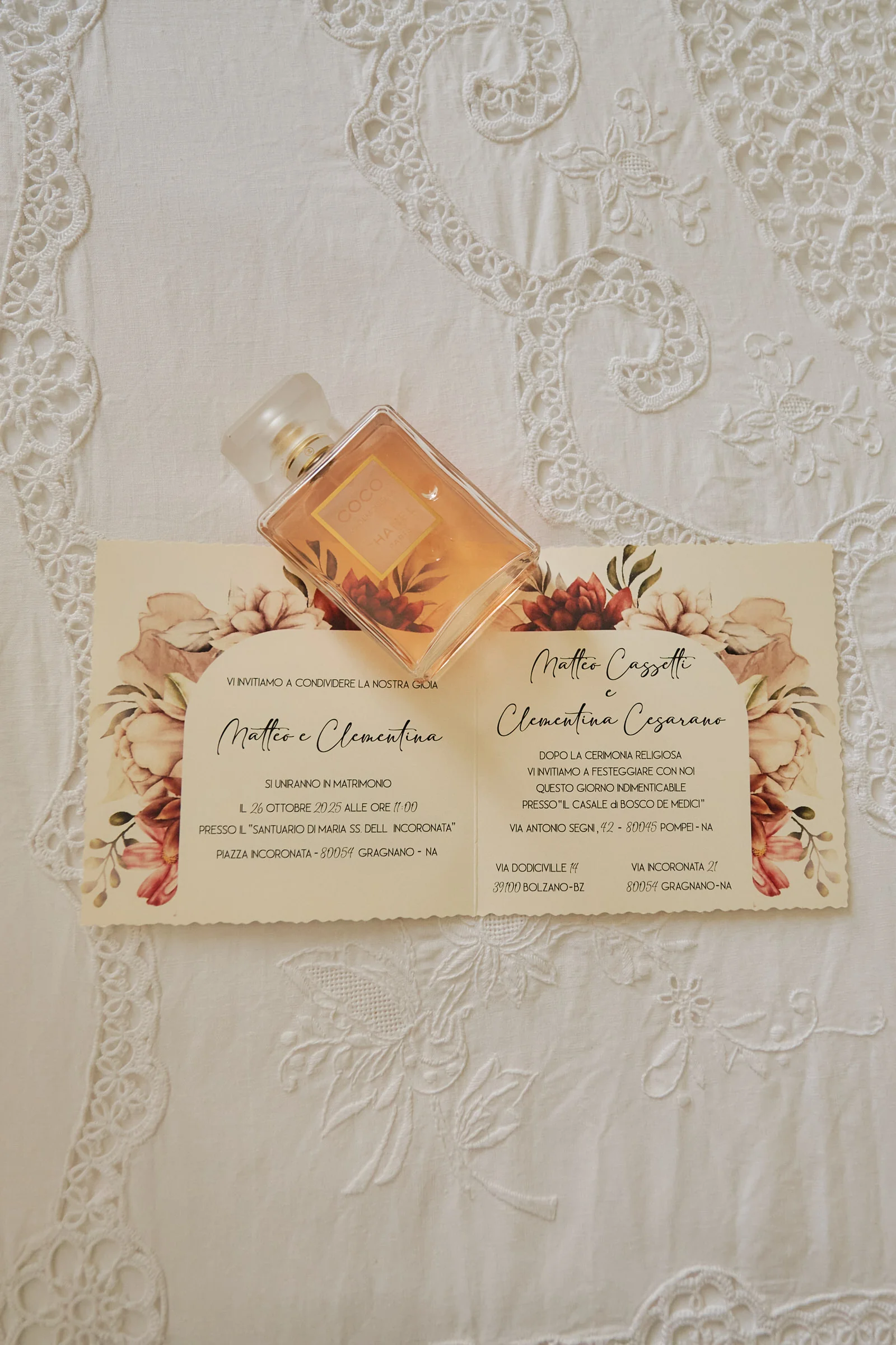 Matteo and Clementina’s wedding invitation with a perfume bottle on embroidered fabric.